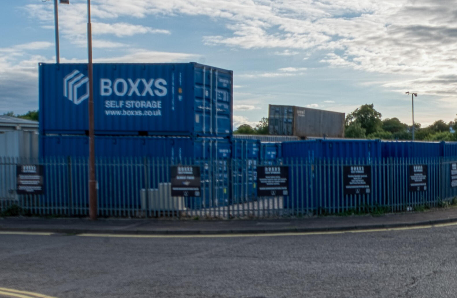 Entrance to Boxxs Self Storage at Mill Road Industrial Estate i Entrance to Boxxs Self Storage at Mill Road Industrial Estate in Linlithgow, with branded containers and secure gated access.